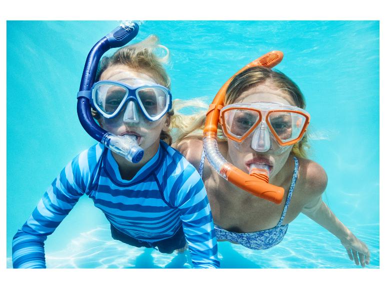 Zwei Kinder schnorcheln unter Wasser, tragen Badeshirts und Bikinis.