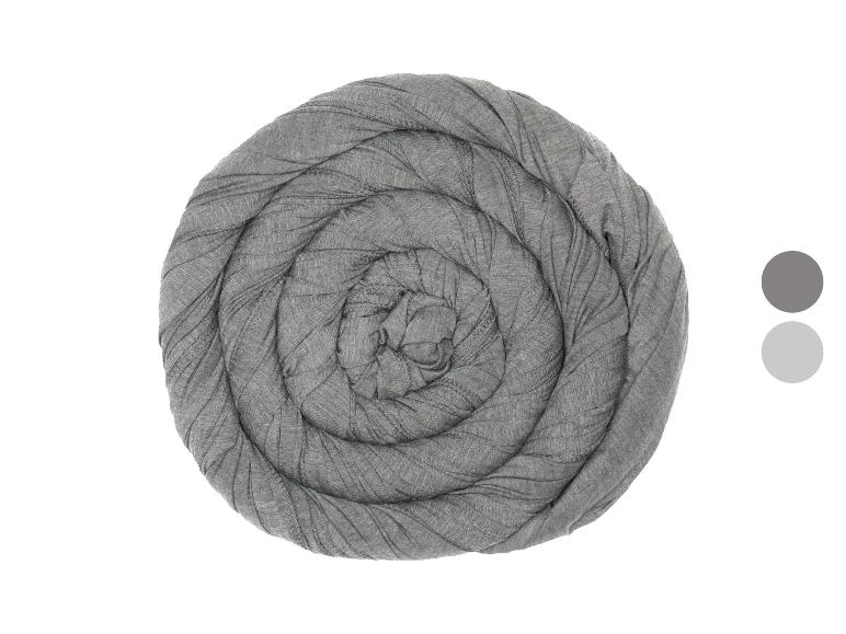 Ein aufgerolltes graues Tuch, möglicherweise eine Decke oder ein Schal, mit zwei Farbmustern.