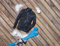 Skier, ein blaues Sweatshirt und Schnee auf einem Holzboden.