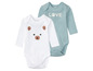 Zwei Baby-Bodys, ein weißer mit einem Bären und ein hellblauer mit 'LOVE'