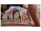 Drei Personen machen Yoga auf rosa Matten auf Gras, tragen Leggings und Sport-Tops.