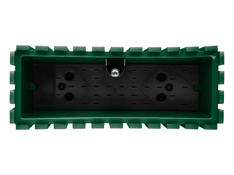 Ein grüner Blumentopf mit Drainagelöchern.