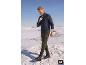 Mann in blauem Pullover und grüner Cargohose geht durch den Schnee.