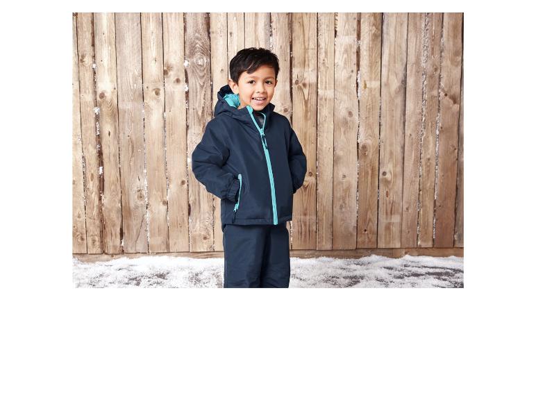 Ein Junge trägt eine blaue Winterjacke und Hose.