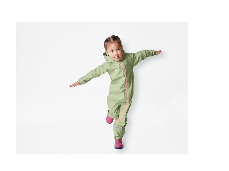 Ein Mädchen trägt einen grünen Regenoverall mit Schmetterlingen und rosa Gummistiefeln.