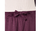 Dunkelviolette Velourhose mit Kordelzug in der Taille, kombiniert mit einem gerippten weißen Oberteil.