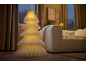 Dekorative Stehlampe in Form eines leuchtenden Weihnachtsbaums in einem gemütlichen Wohnzimmer.