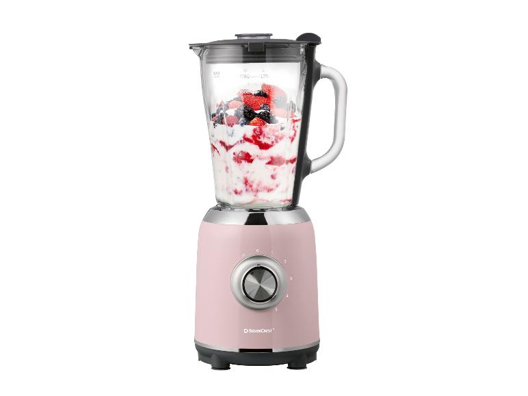 Rosa Mixer mit Beeren und Joghurt im Glasbehälter.