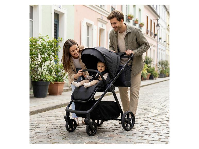 Eltern mit Baby im FILLIKID Lion Kinderwagen auf Kopfsteinpflaster.