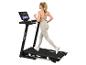 Junge Frau läuft auf einem Laufband mit Touchscreen-Display, in grauer Sportkleidung.