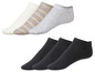 Sechs Paar Socken, drei weiß, grau und gestreift und drei schwarz.