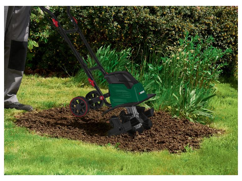 Person benutzt eine Parkside Elektro-Bodenhacke zur Bodenbearbeitung in einem Gartenbeet.