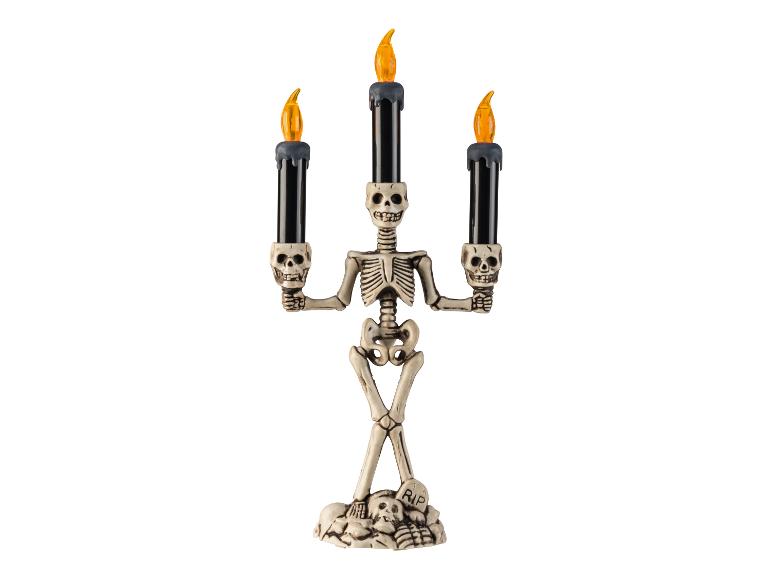Halloween-Skelett-Kerzenständer mit drei schwarzen Kerzen und orangefarbenen Flammen