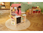 Mädchen spielt mit einem Holzspielzeugladen, weihnachtlich dekoriert.