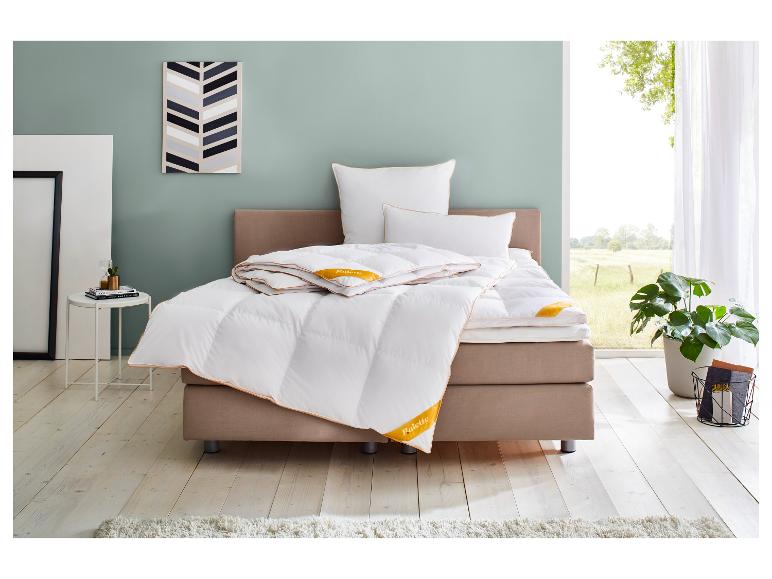 Schlafzimmer mit Bett, weißen Palette-Bettdecken und Kissen, einem Beistelltisch und einer Pflanze.