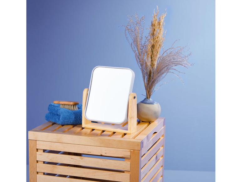 Ein Holzspiegel mit einer Bürste und einem Handtuch auf einer Holzkiste.