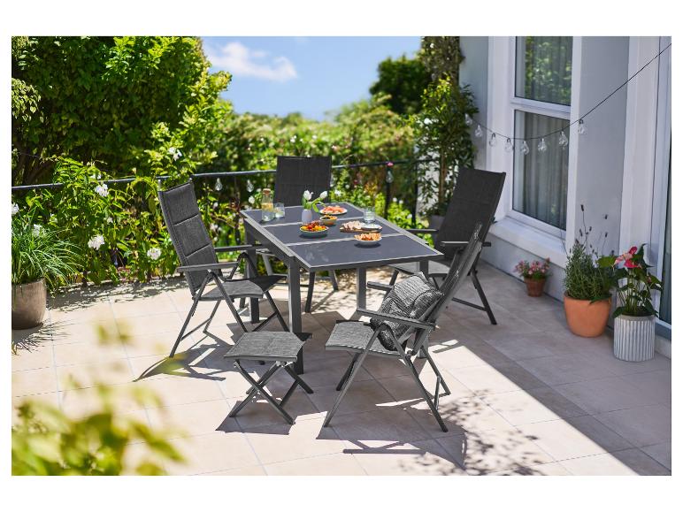Gartenmöbel-Set mit Tisch und Stühlen, mit Essen auf einer sonnigen Terrasse.
