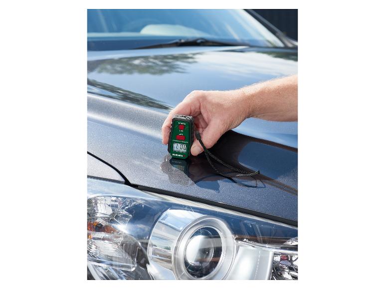 Ein Mann benutzt ein PARKSIDE Lackdickenmessgerät auf einer Motorhaube.