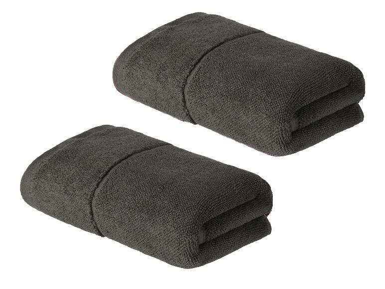 Zwei dunkelgraue Handtücher, gefaltet und gebrauchsfertig.