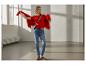 Lächelnde Frau in rotem ESMARA® Grobstrick-Cardigan und Jeans.