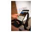 Person benutzt Tablet auf einem Heimtrainer, zeigt Straßenansicht und Trainingsdaten an.
