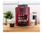 Rote Kaffeemaschine mit zwei Espressotassen und weiteren Kaffeegetränken auf einer Holztheke.