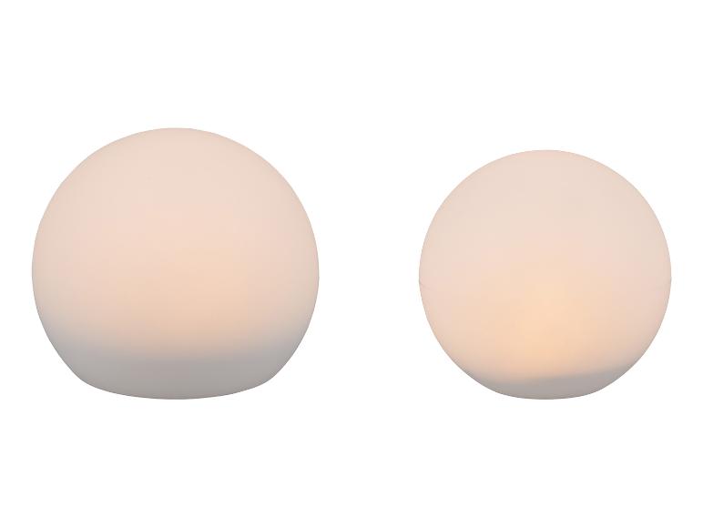 Zwei kugelförmige Tischlampen mit warmem Licht auf weißem Hintergrund.