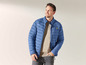 Mann in blauer Steppjacke mit kleinem Logo