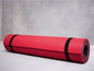 Eine rote Yogamatte mit schwarzen Bändern.