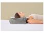 Frau schläft auf dem Rücken auf einem Bett mit einem grauen ergonomischen Kissen