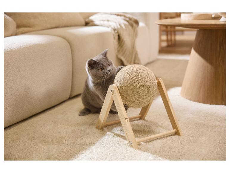 Graue Katze spielt mit einem Kratzball aus Seil auf einem Holzständer.