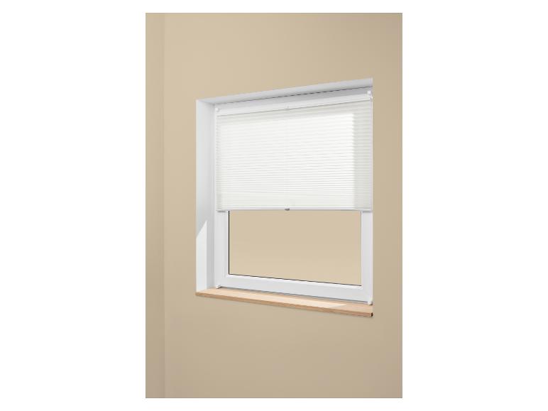 Fenster mit weißem Plissee und heller Holzfensterbank an einer beigen Wand.