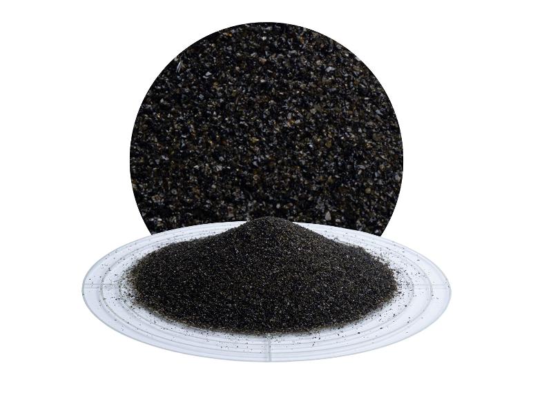 Ein Haufen schwarzer Sand auf einem transparenten Teller, mit einer Nahaufnahme des Sandes darüber.