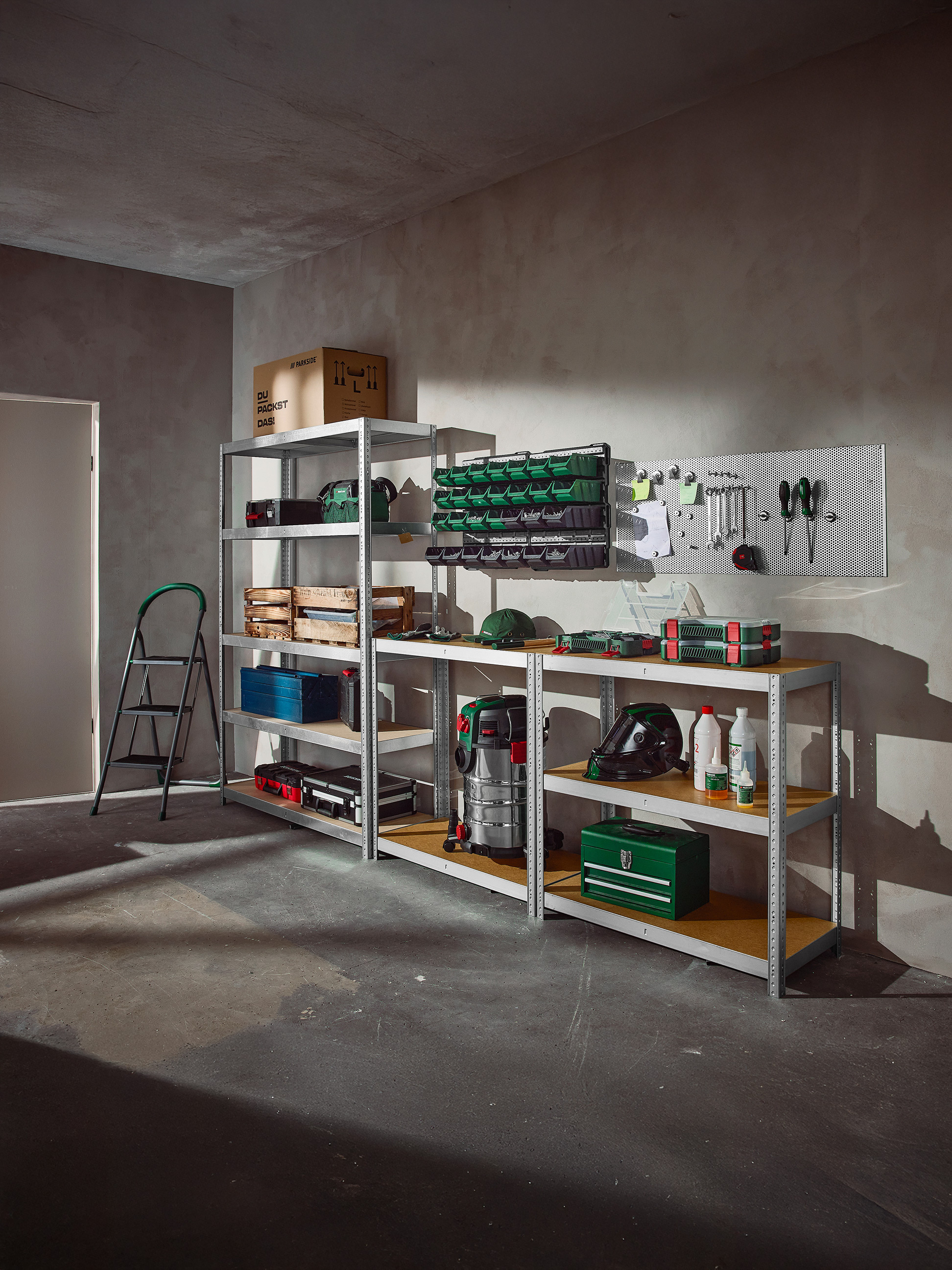 Organisierte Garage mit Regalen voller Werkzeuge, Aufbewahrungsboxen und Werkstattausrüstung.