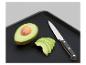 Geschnittene Avocado, Messer und schwarzes Schneidebrett.
