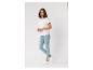 Frau in weißem T-Shirt, hellblauer Jeans und weißen Sneakern.