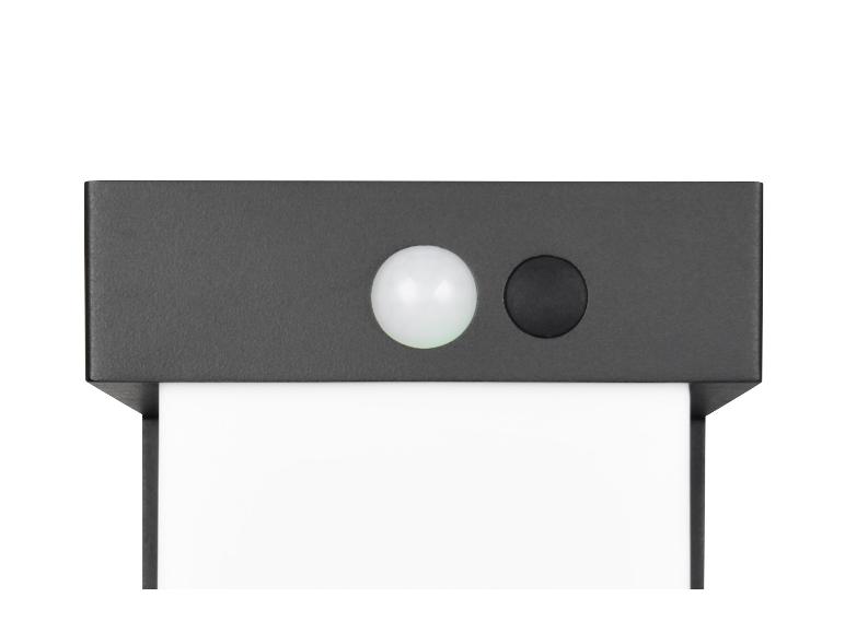 Draufsicht auf einen dunkelgrauen Bewegungssensor mit einer weißen kugelförmigen Linse und einem schwarzen Knopf