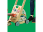 Kleinkind spielt mit einem hölzernen Lauflernwagen mit Aktivitätsboard, daneben ein Erwachsener.