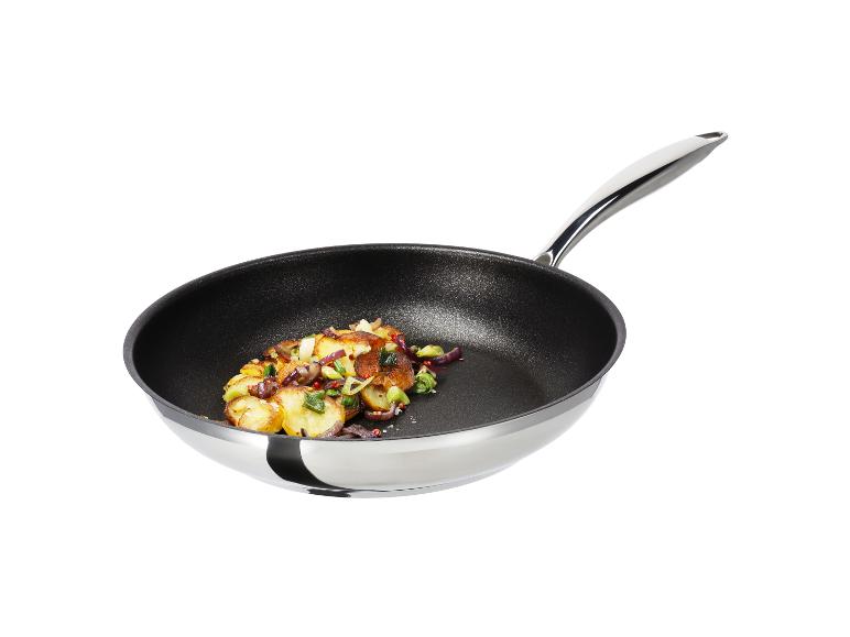 Bratkartoffeln mit roten Zwiebeln und Lauch in einer schwarzen Pfanne mit silbernem Griff