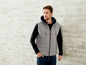 Mann trägt eine graue Steppweste mit Kapuze