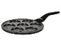Schwarze Pfannkuchenpfanne mit sieben runden Formen mit Smiley-Gesichtern.