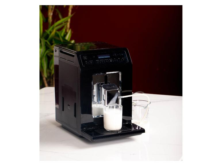 Schwarze Krups Kaffeemaschine mit Milchaufschäumer und einem Glas Milch