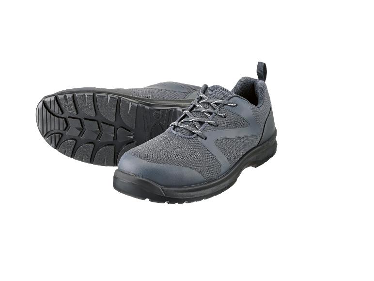 Ein Paar graue Schnür-Arbeitsschuhe, ein Schuh liegt auf der Seite und zeigt die Sohle.