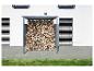 Metallschuppen für Brennholz, gefüllt mit geschnittenem Holz, neben einem weißen Haus