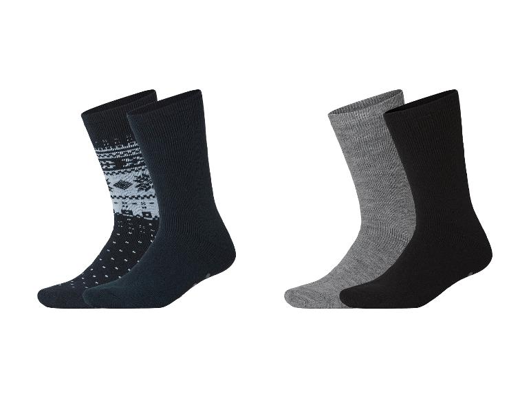 Zwei Paar Socken: eines mit Norwegermuster und einfarbig, das andere grau und schwarz.