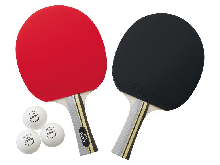 Zwei Crivit Tischtennis Schläger, rot und schwarz, mit drei Bällen.
