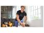 Mann in schwarzem Sport-T-Shirt und blauen Shorts dehnt sich in einem Fitnessstudio mit Trainingsgeräten.