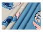 Stoff mit blauem und beigem Cartoon-Charakter-Print, mit Falten.