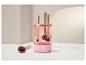 Rosa Make-up-Pinselreiniger mit Pinseln darin, neben einem schmutzigen Pinsel und Puder.