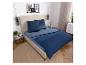 Schlafzimmer mit blauer Bettwäsche, Nachttischen und Wanddekorationen.